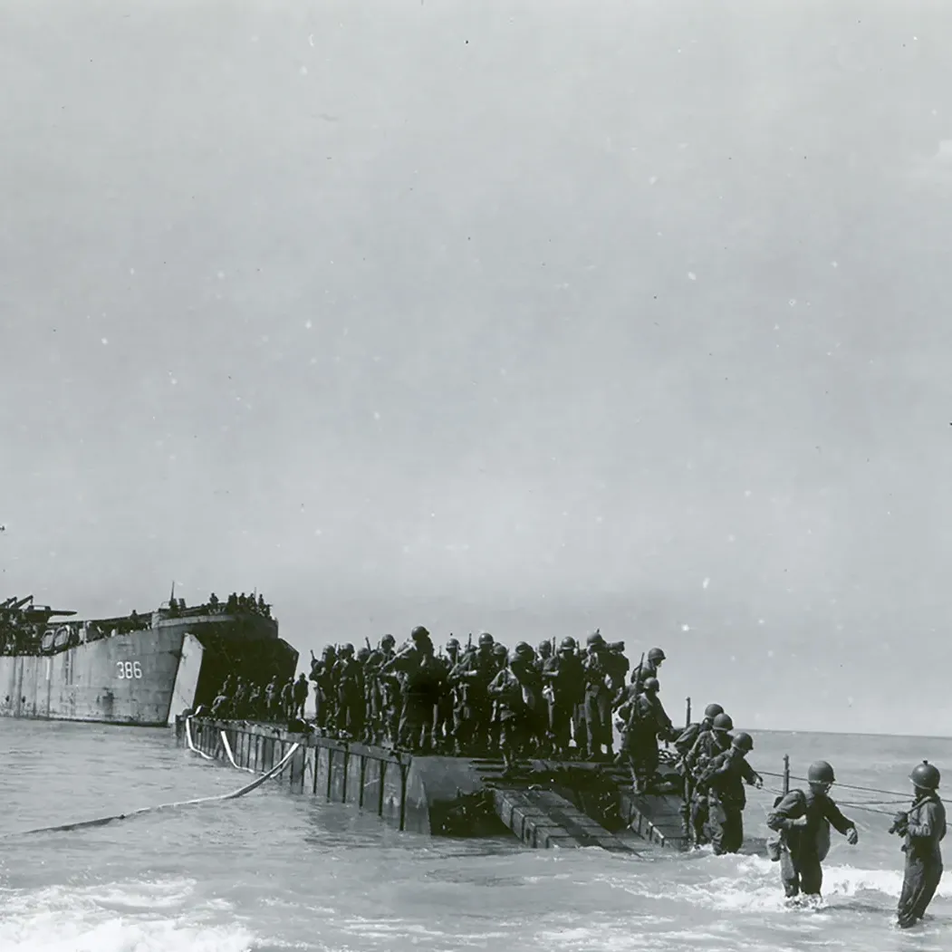 Allied troops disembarking from an LST (landing ship, tank) invasion barge onto a beach near Licata, Sicily, July 10, 1943.