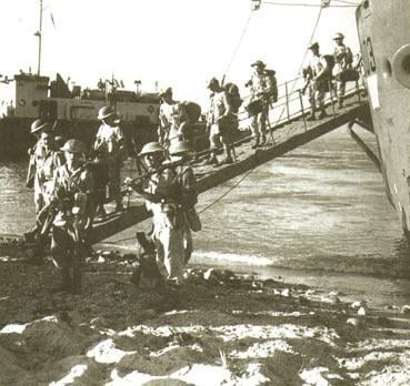 British troops walk down the ramp of their landing craft in an unopposed landing on the coast of Italy in September 1943.